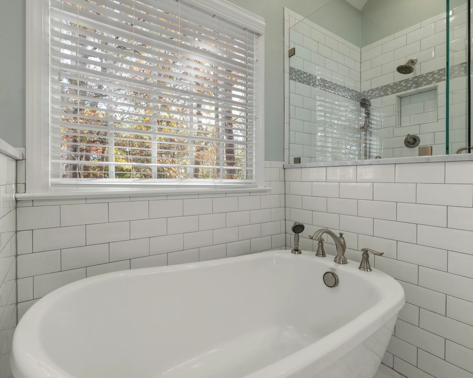 Placeholder after image of a bright bathroom with a white tub and shower.