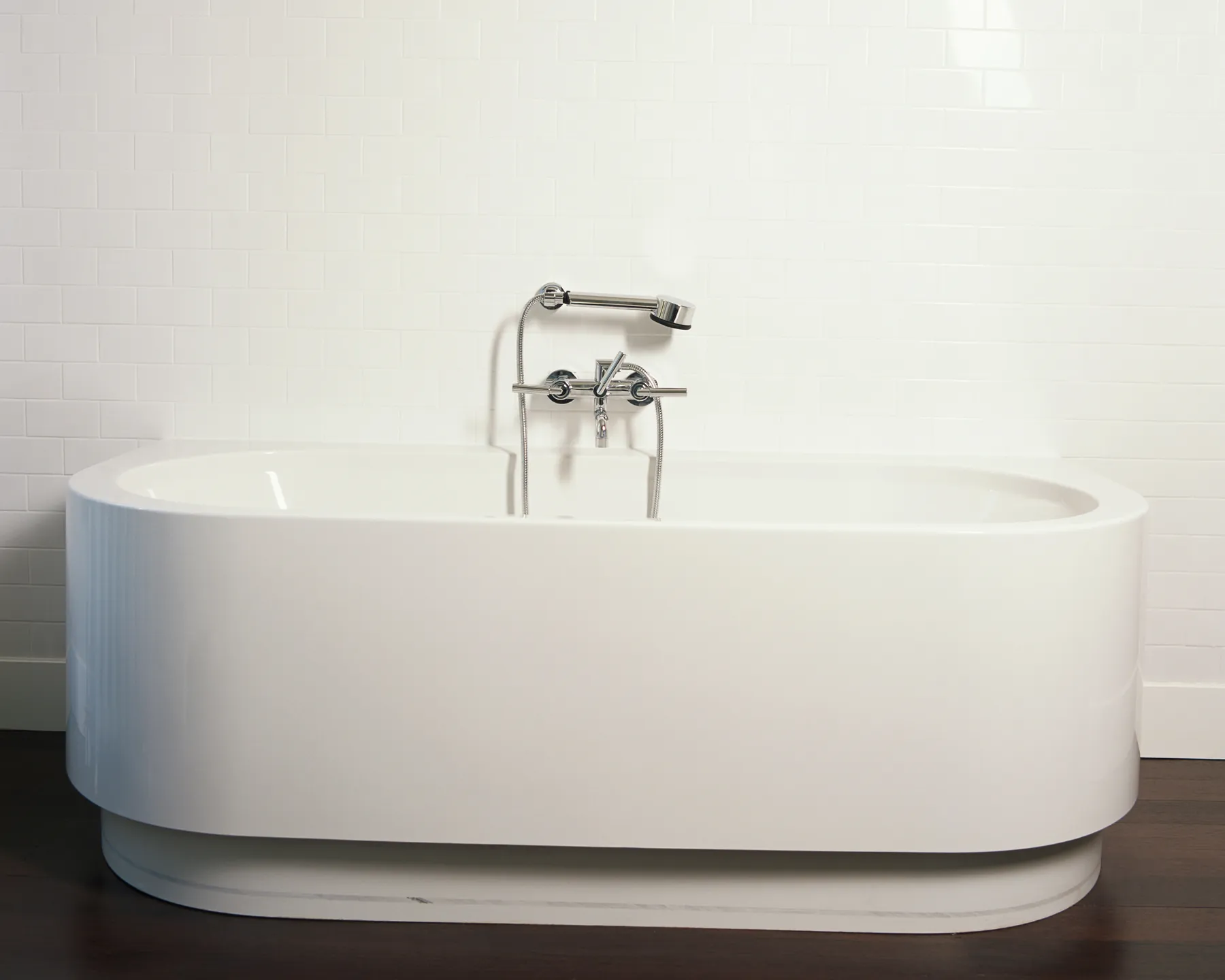 Placeholder before photo of a freestanding tub against white tile.